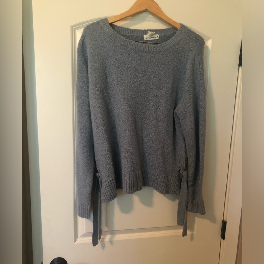 Grey/blue sweater with ties on the bottom sides